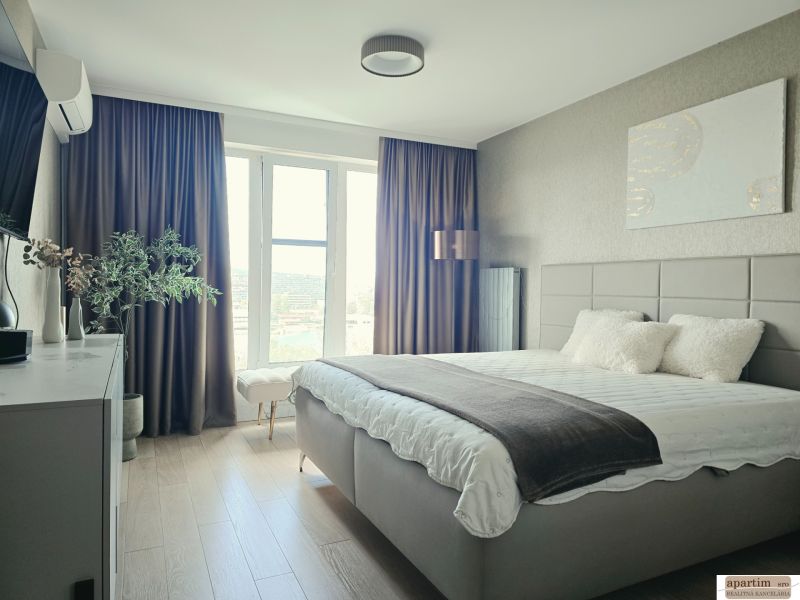 A bedroom in a 4-room apartment with a wood-patterned floor and a large window.