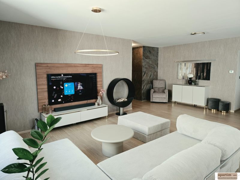Living room in a 4-room apartment with a fireplace, sofa, and floor with wooden decor.