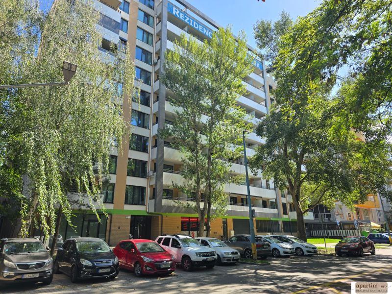 A high-rise residential building surrounded by trees on Antolská Street in Bratislava, Petržalka.
