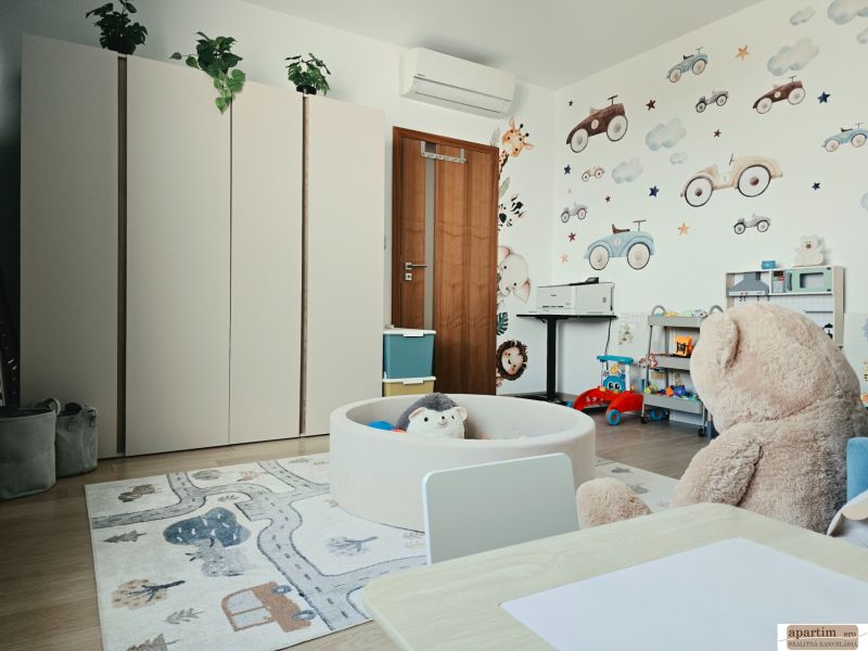 Children's room in a 4-room apartment with colorful furniture, wall decorations, and a wooden decor floor.