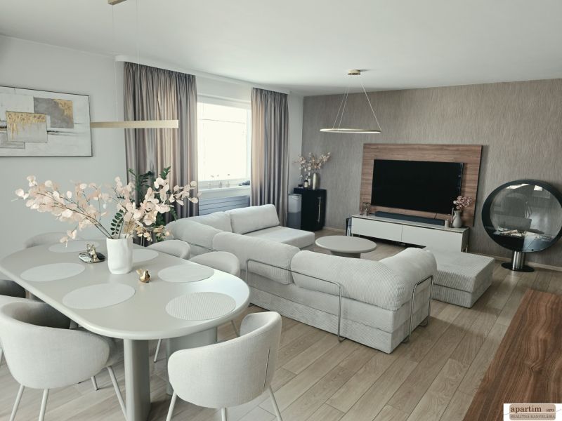 A stylish living room with a comfortable sofa, dining table, and wooden decor flooring in a 4-room apartment.