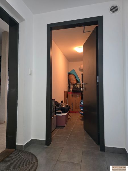 A hallway with gray tiles and a storage room in a 4-room apartment.