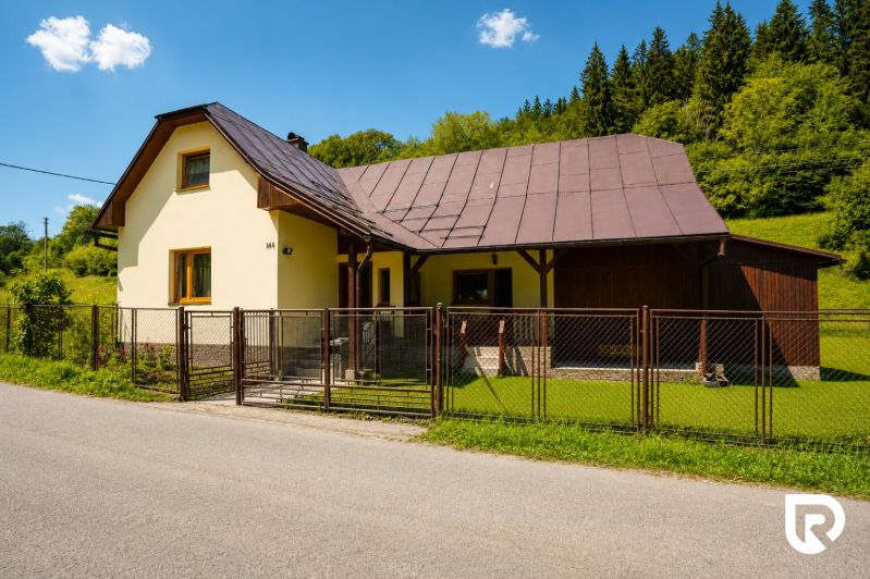 A cottage on Čierne Street in Makov with an ornamental lawn and a wooden fence.