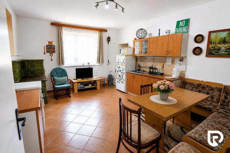 A kitchen in a family house with a fireplace, furniture, and decorations, with a wooden decor floor.