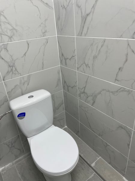 A restroom with marble tiles in commercial spaces, gray floor.