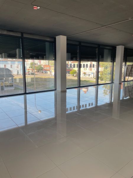 Large commercial spaces with glass walls and shiny floors.