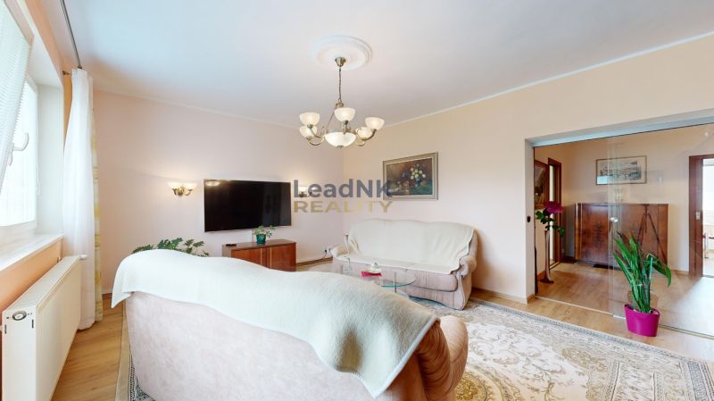 Living room in a 3-room apartment with a sofa, television, and a light carpet.