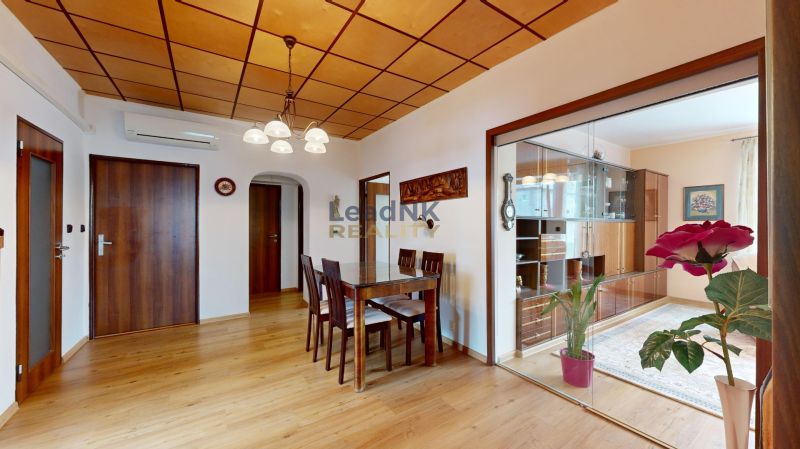 Dining table and chairs on a wooden-decor floor in a 3-room apartment.