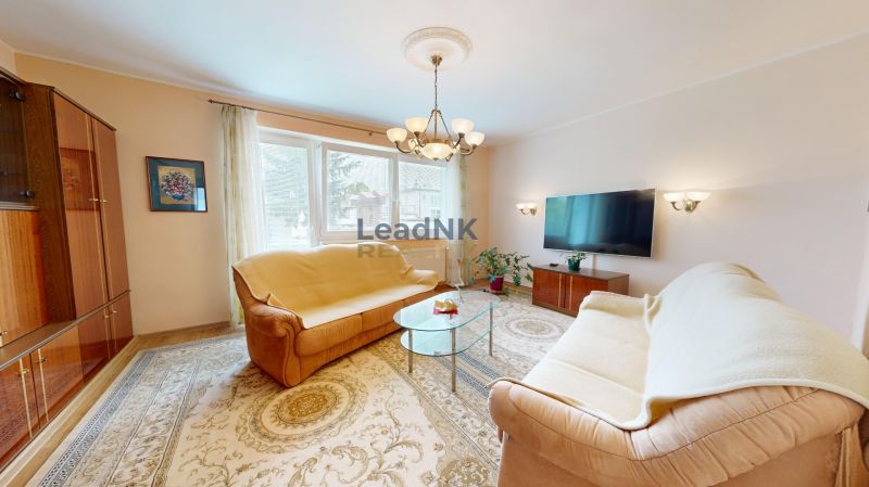 Living room with carpets, sofas, and a television in a 3-room apartment.