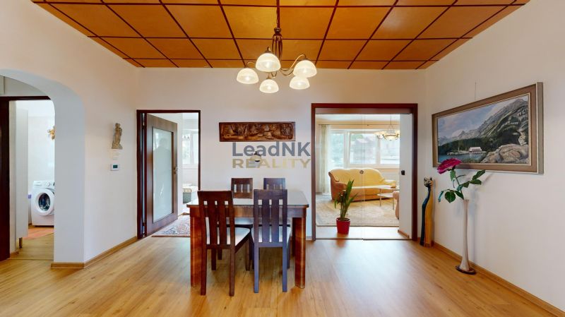 Dining table and chairs, wooden decor flooring, picture and decorations in a 3-room apartment.