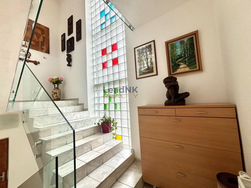 Nicely lit stairs with decorations, artworks, and flowers in a 3-room apartment.