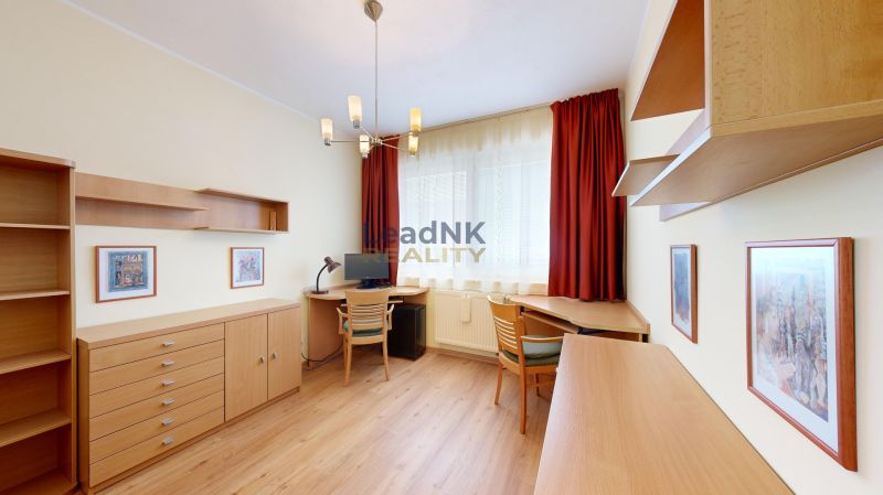 A room in a 3-room apartment with a wooden decor floor and light furniture.