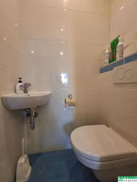 A toilet with a sink in a 3-room apartment has light tiles.