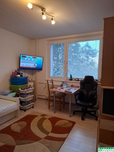 Children's room with a bed, desk, and floor with wooden decor in a 3-room apartment.