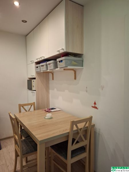 Dining area with a table and chairs in a 3-room apartment. Floor with wood decor.