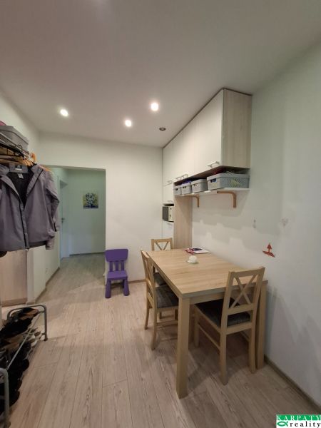 Dining room in a 3-room apartment with wood-patterned flooring and built-in cabinets.