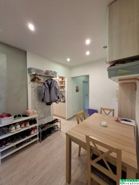 Dining room in a 3-room apartment with open space and wooden decor flooring.