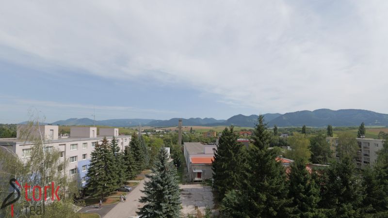 A view of Mudrochova Street in Rajec with a view of nature and buildings.