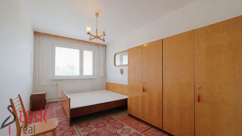 A bedroom with a bed, wardrobes, and a carpet in a two-room apartment.