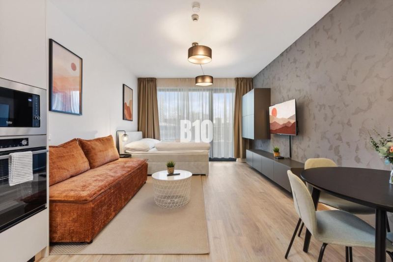 1-bedroom apartment with wood-patterned flooring, a television, and comfortable seating.