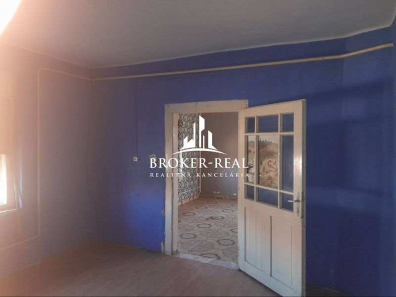 Blue room in a family house with connecting doors and a wooden decor floor.