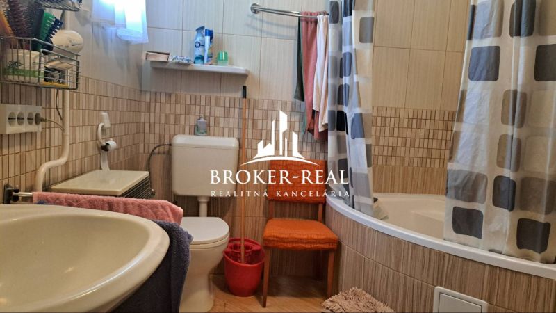 A bathroom in a family house with a bathtub, a sink, and colorful towels.