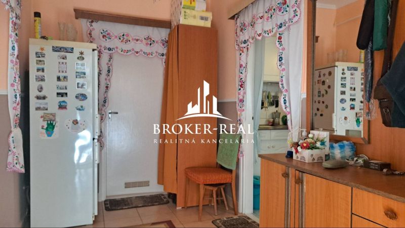 Interior of a family house with a kitchen, decorative curtains, and a decorated refrigerator.