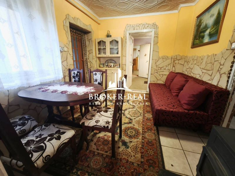 Dining room in a family house with a decorative table and a red sofa.