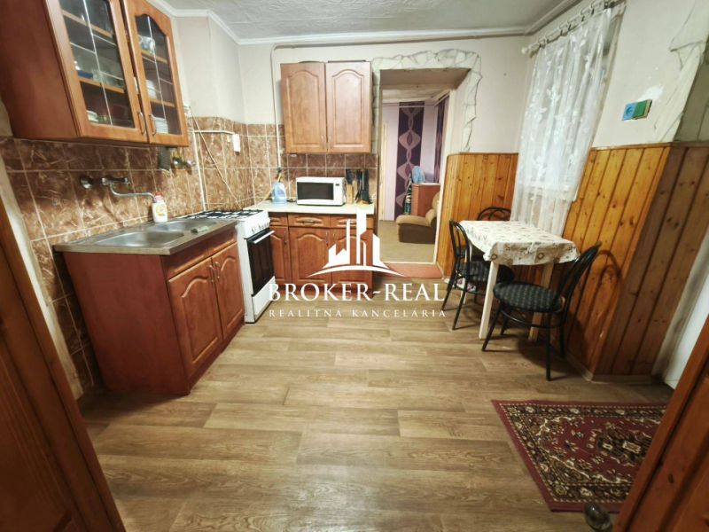 A kitchen in a family house with wooden decor, cabinets, and a dining area.