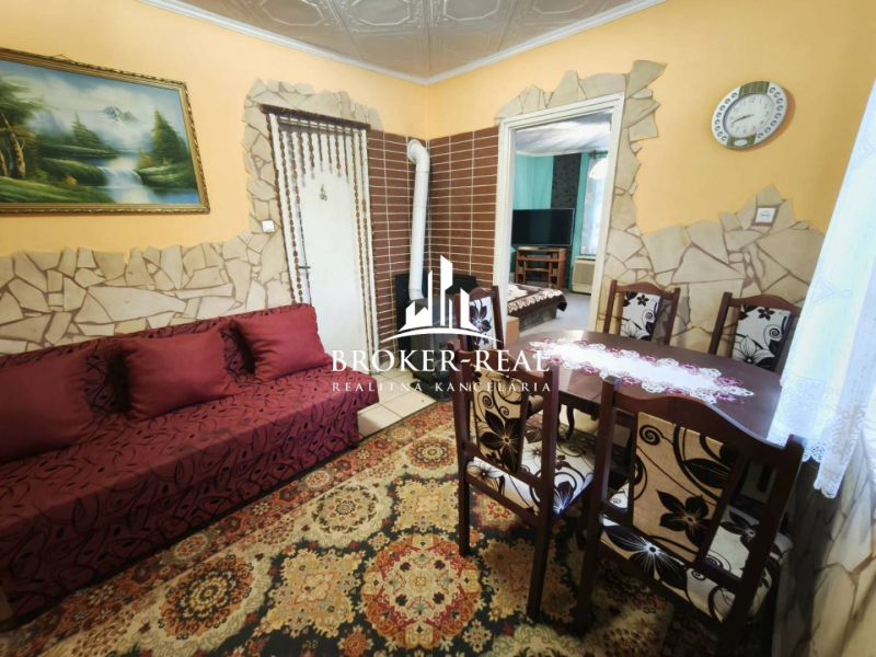 Living room in a family house with a nature painting and a wooden dining table.