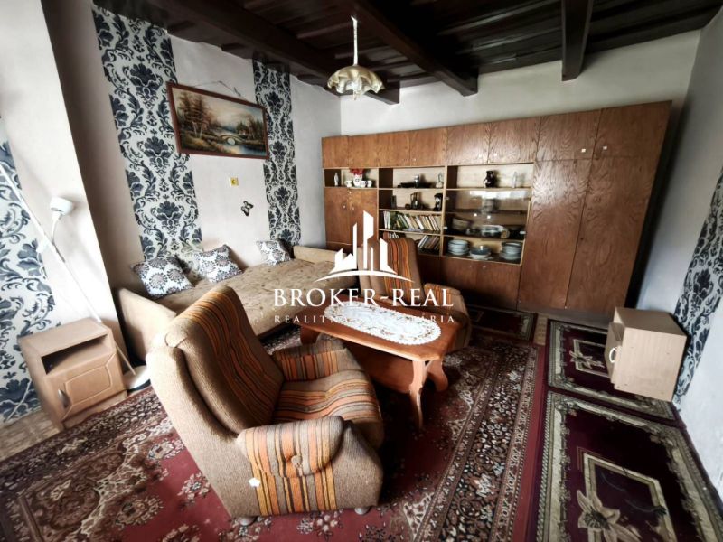 Living room in a family house with carpets and a wooden living room set.