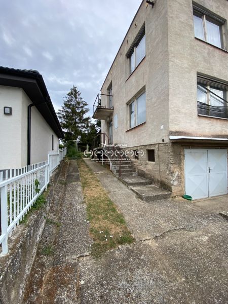A family house on Zvončín Street in the town of Zvončín with a concrete sidewalk and a garage.