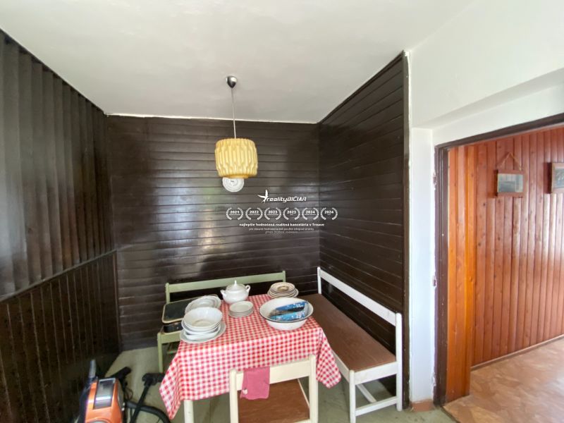 Interior of a family house with dark wood paneling and a dining area.