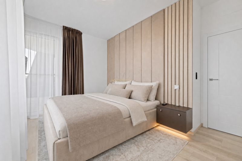 Elegant bedroom with neutral colors and wood-patterned flooring in a three-room apartment.