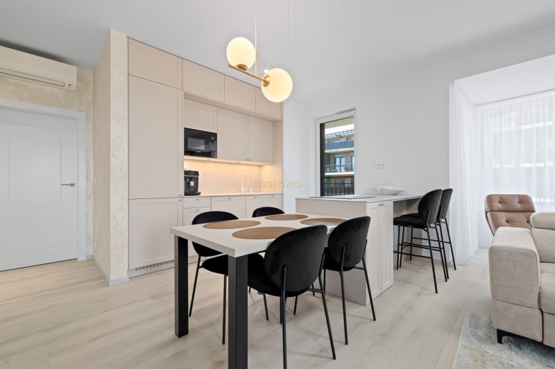 A kitchen in a 3-room apartment with white cabinets and a wood-patterned floor.