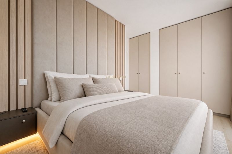 A bedroom in a three-room apartment with a comfortable bed and built-in wardrobes in neutral colors.
