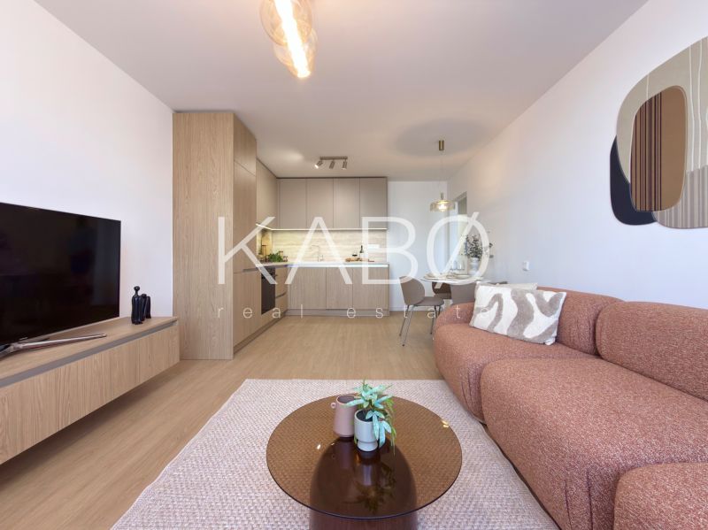 Living room in a 3-room apartment with a wooden decor floor and light furniture.