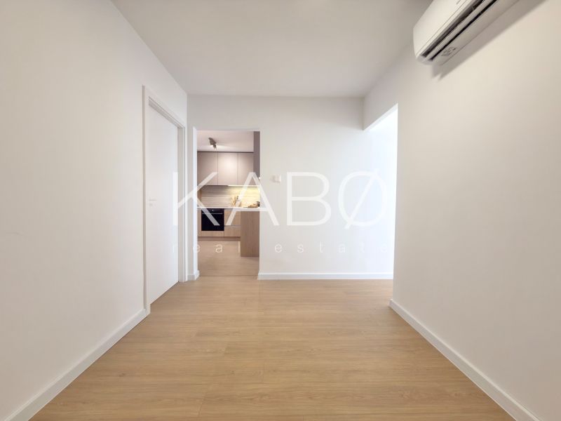 A hallway in a 3-room apartment with a wooden decor floor and air conditioning.