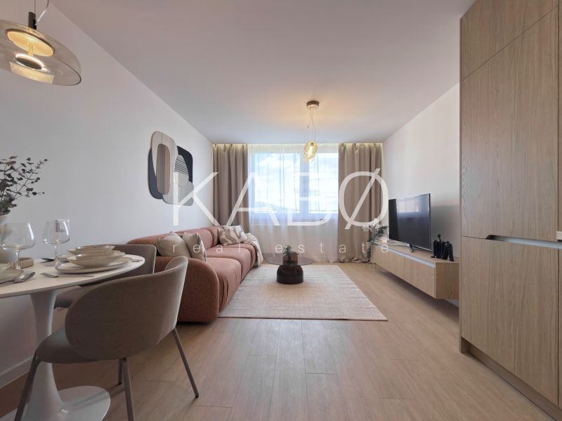 A living room in a 3-room apartment with a wooden decor floor, a sofa, and a dining table.