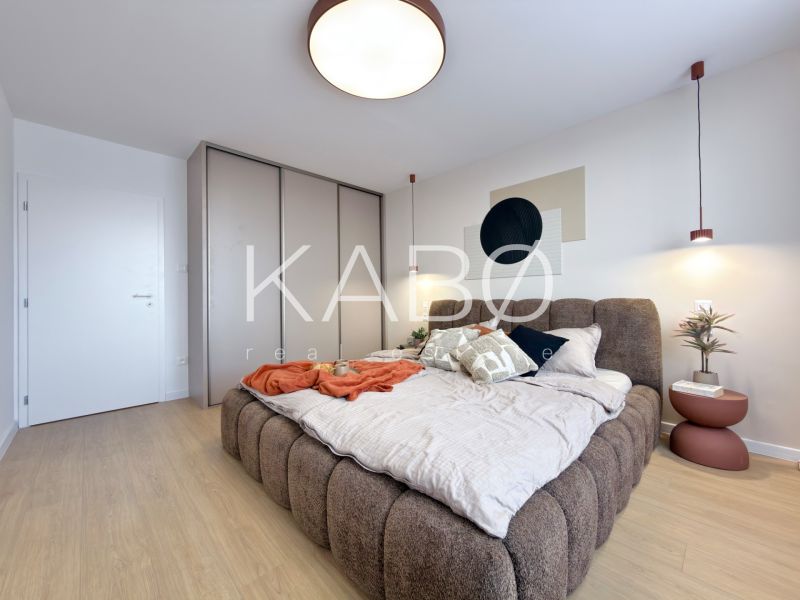 A bedroom in a 3-room apartment with a large bed and a floor with a wooden decor.