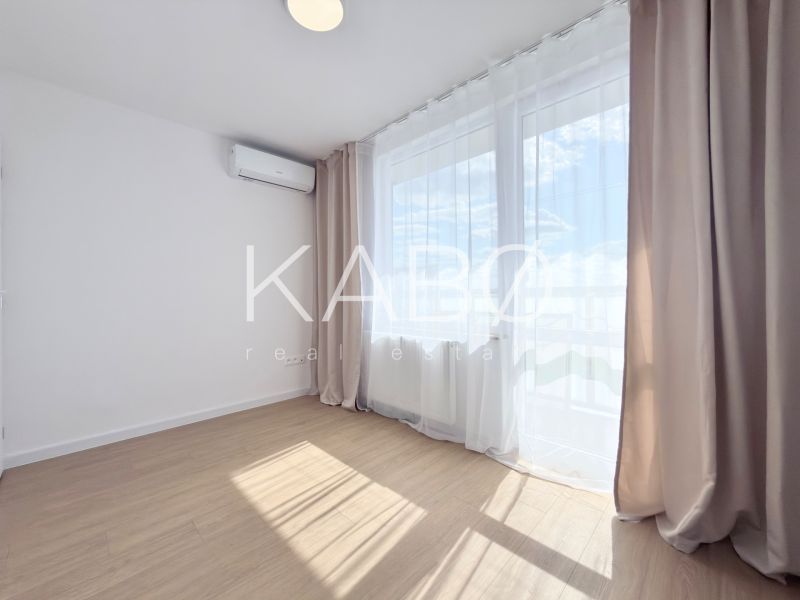 A room with a wooden decor floor and air conditioning in a 3-room apartment.