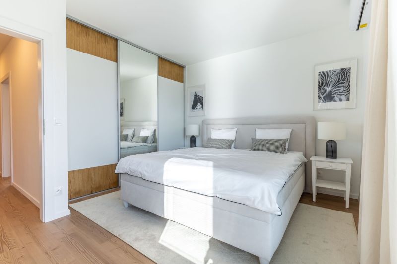 Bright bedroom in a family house with a large bed and a wardrobe.
