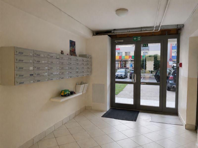 Entrance hall of a 3-room apartment with mailboxes and glass doors.