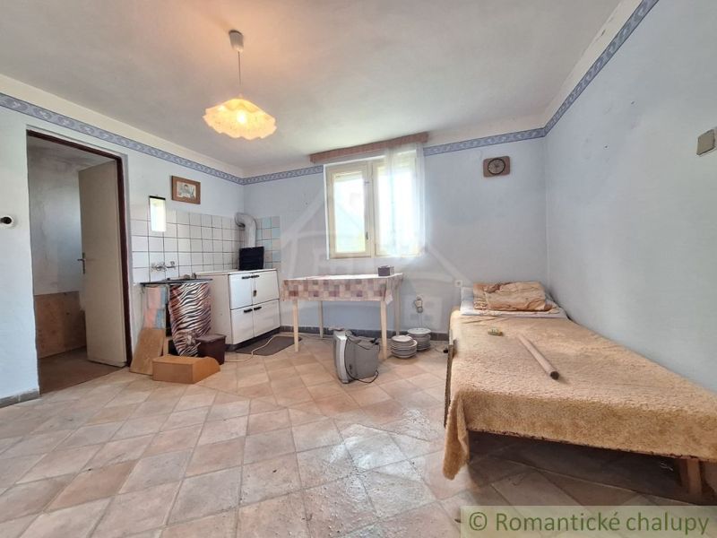 In the family house, there is a simple room with a kitchenette and an armchair.