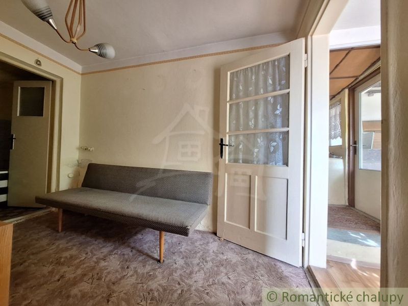 Bright room with a sofa and glass doors in a family house.