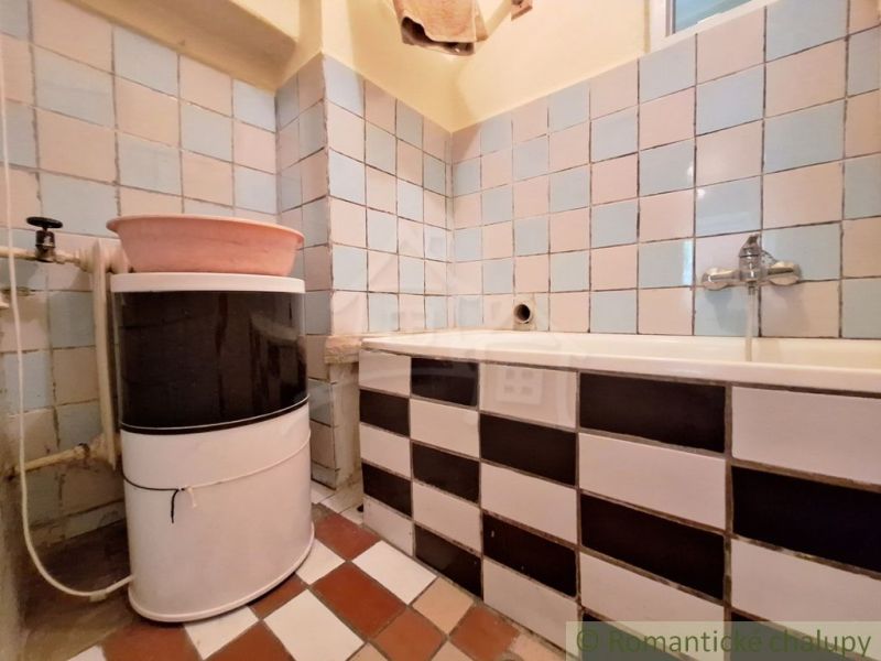 A bathroom in a family house with a sink and a bathtub, tiled.