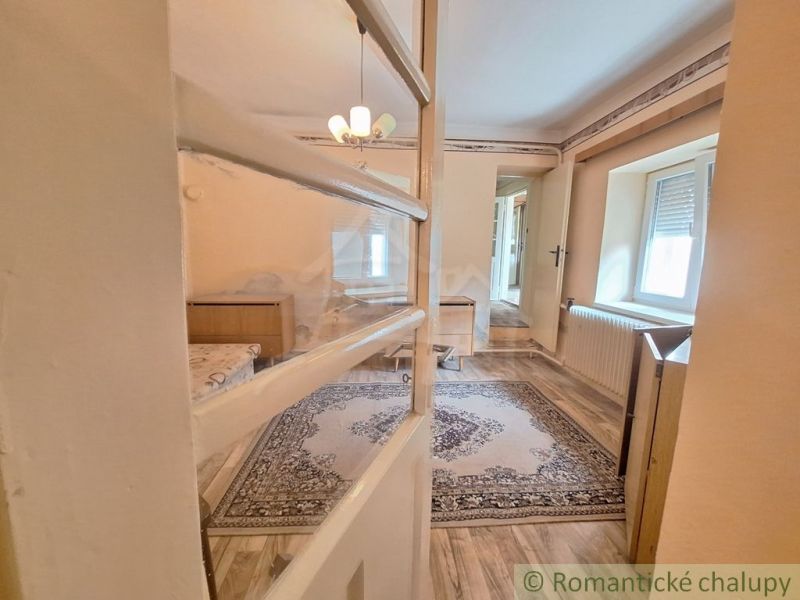 Interior of a family house with a wooden decor floor, carpet, and chandelier.