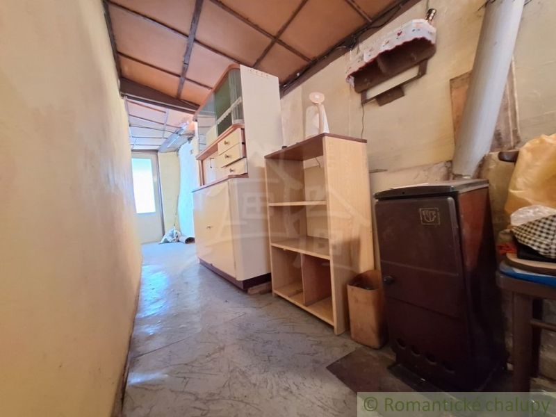 A narrow hallway in a family house with gas stoves, shelves, and a wardrobe.