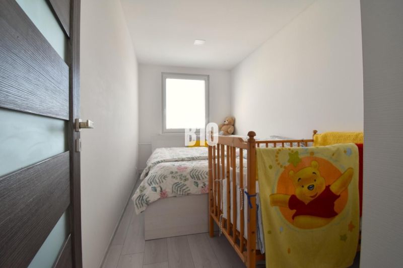 Children's room in a 3-room apartment with white walls and a crib.