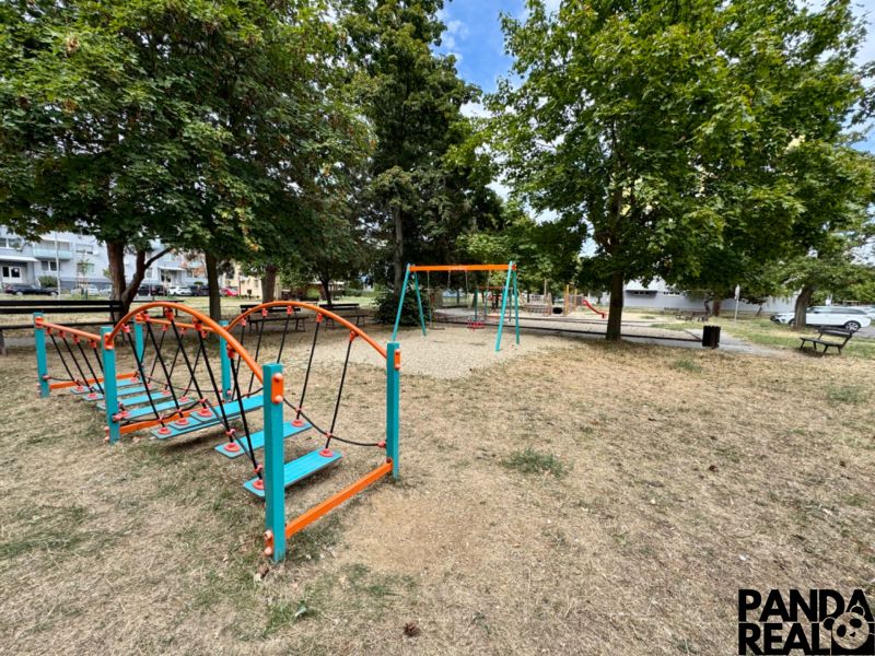 A children's playground in Topoľčany with various attractions and benches in the park.